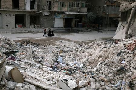 People walk past damaged buildings in the rebel held area of al-Kalaseh neighbourhood of Aleppo, Syria, September 29, 2016. REUTERS/Abdalrhman Ismail