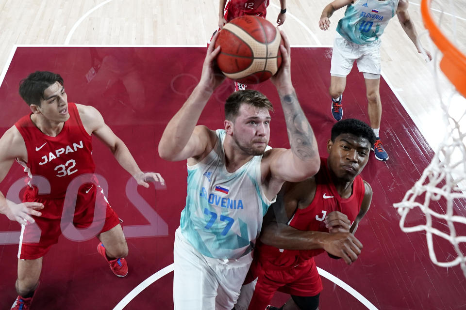 Slovenia's Luka Doncic (77) drives to the basket against Japan's Rui Hachimura, right, during a men's basketball game at the 2020 Summer Olympics, Thursday, July 29, 2021, in Saitama, Japan. (AP Photo/Eric Gay)