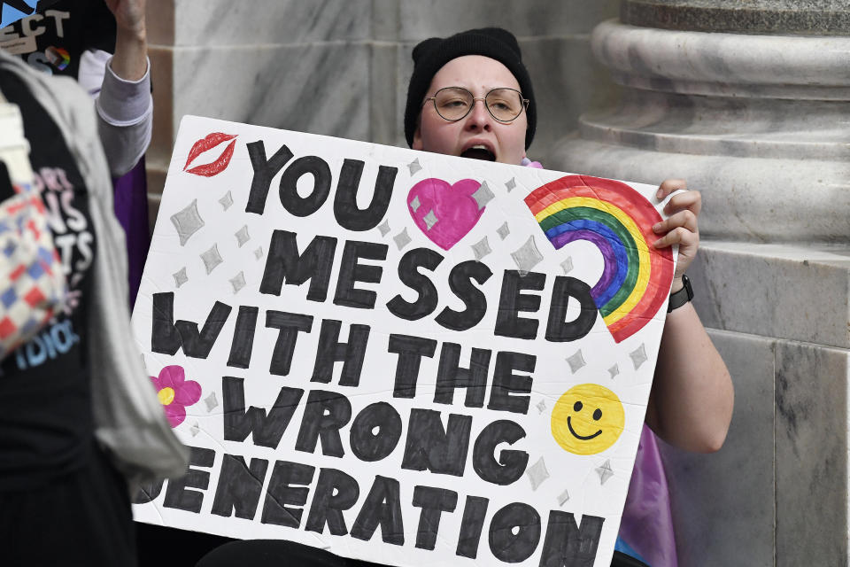 A protester holds a sign opposing the Kentucky bill  outside the Senate chamber at the state Capitol in Frankfort, Ky., on Wednesday, March 29.