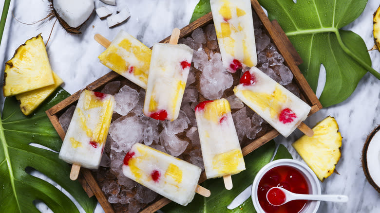 two hands holding popsicles