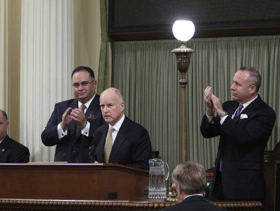 Gov. Jerry Brown, center, receives applause from legislative leaders, Assembly Speaker John Perez, D-Los Angeles, left, and Senate President Pro Tem Darrell Steinberg, D-Sacramento, before he delivers his State of the State address at the Capitol in Sacramento, Calif., Wednesday, Jan. 22, 2014. Brown delivered a dual message in his annual address to the Legislature, that a California resurgence is well underway but is threatened by economic and environmental uncertainties.(AP Photo/Rich Pedroncelli)