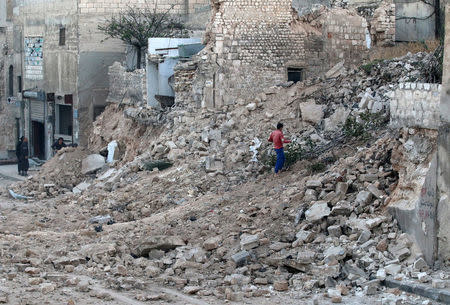 A civilian collects tree branches amid the rubble of a damaged site in the rebel-held besieged Qadi Askar neighbourhood of Aleppo, Syria November 24, 2016. REUTERS/Abdalrhman Ismail