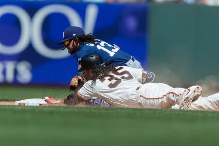 Jun 23, 2018; San Francisco, CA, USA; San Francisco Giants shortstop Brandon Crawford (35) slides in safe on a double as San Diego Padres shortstop Freddy Galvis (13) tries to take him in the eighth inning at AT&T Park. Mandatory Credit: John Hefti-USA TODAY Sports