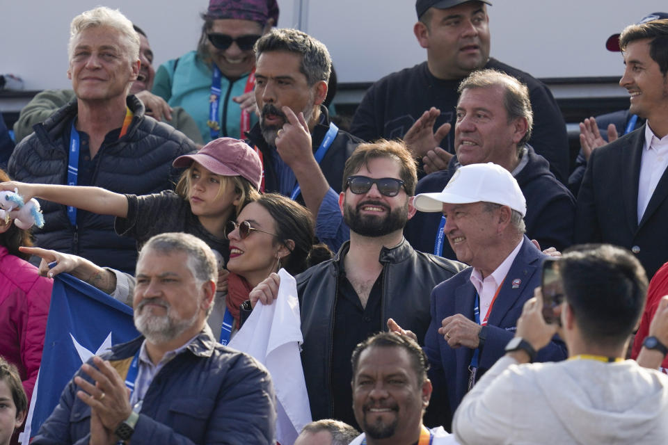 Chile's President Gabril Boric, center, attends the men's beach volleyball bronze medal match between Chile and the United States at the Pan American Games in Santiago, Chile, Friday, Oct. 27, 2023. (AP Photo/Esteban Felix)