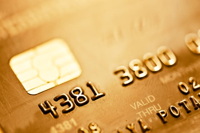 Close-up of a gold-colored credit card showing part of the number and the EMV chip.