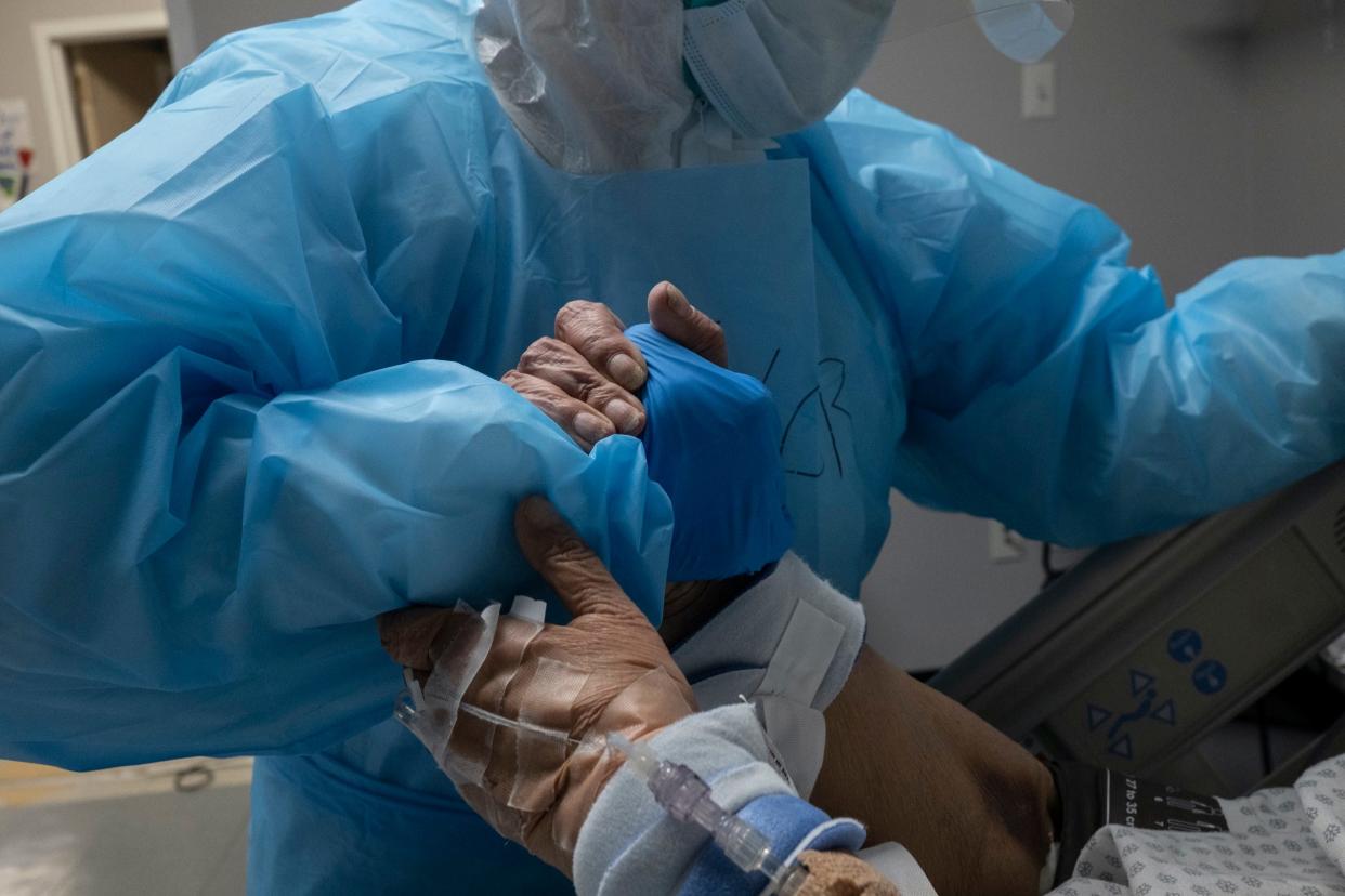 covid houston hospital HOUSTON, TX - OCTOBER 31: A medical staff member grabs a hand of a patient to reposition the bed in the COVID-19 intensive care unit (ICU) at the United Memorial Medical Center (UMMC) on October 31, 2020 in Houston, Texas. According to reports, Texas has reached over 916,000 cases, including over 18,000 deaths. (Photo by Go Nakamura/Getty Images)