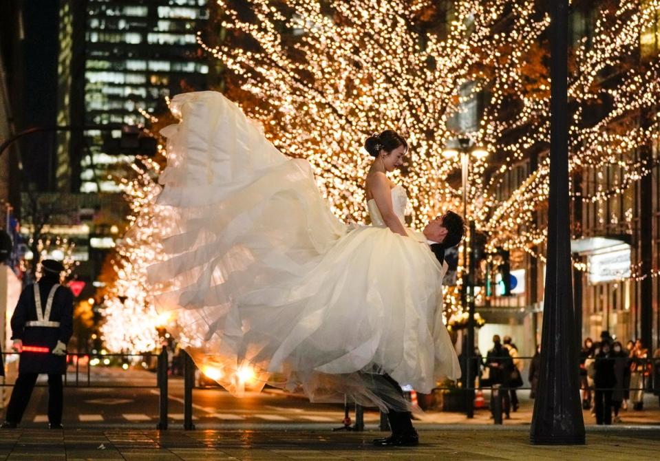 20 December 2022: A soon-to-be married couple poses for photos in central Tokyo (EPA)