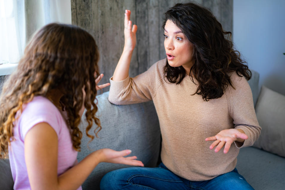 Woman argues with her teenage daughter while sitting at home