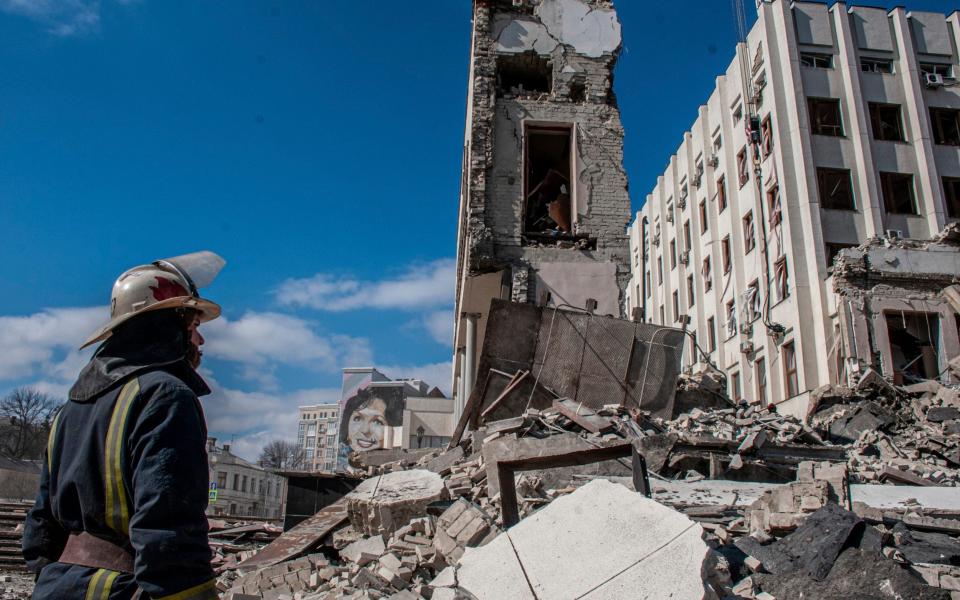 Rescuers at the site of the National Academy of State Administration building destroyed by shelling in Kharkiv, Ukraine