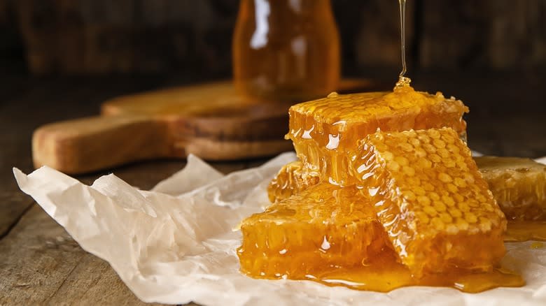 honey dripping onto piled honeycomb