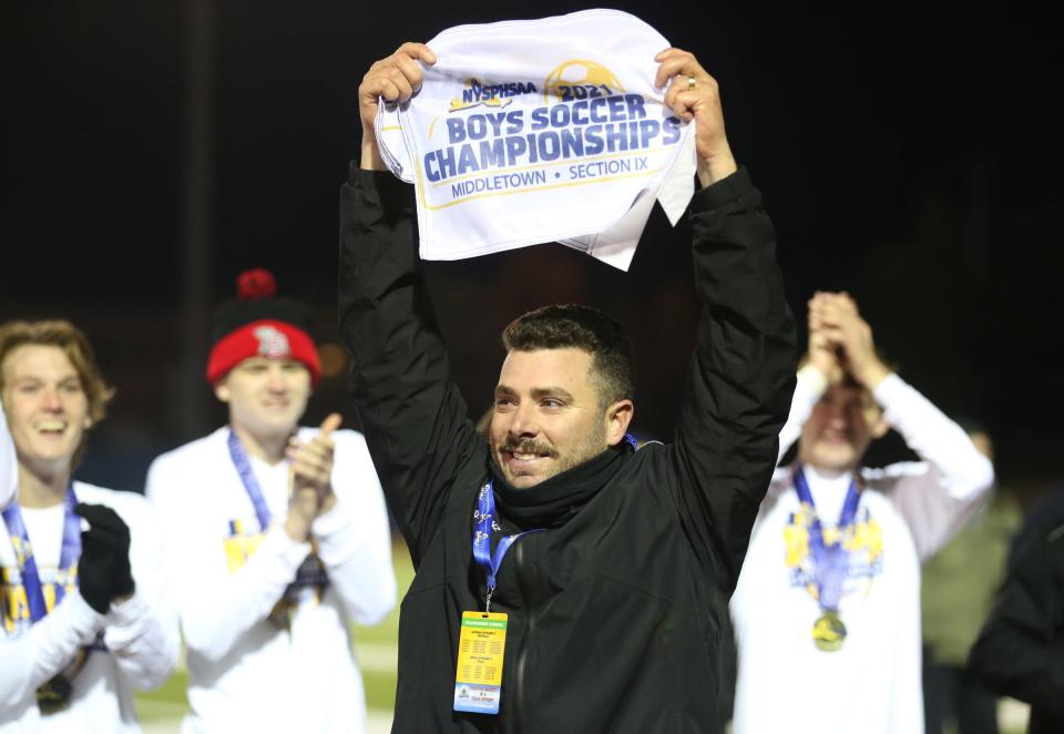 Somers head coach Brian Lanzetta holds up the champion corner flags after their 7-2 win over Amityville Memorial in the NYSPHSAA boys soccer Class A championship game at Middletown High School on Sunday, November 14, 2021.