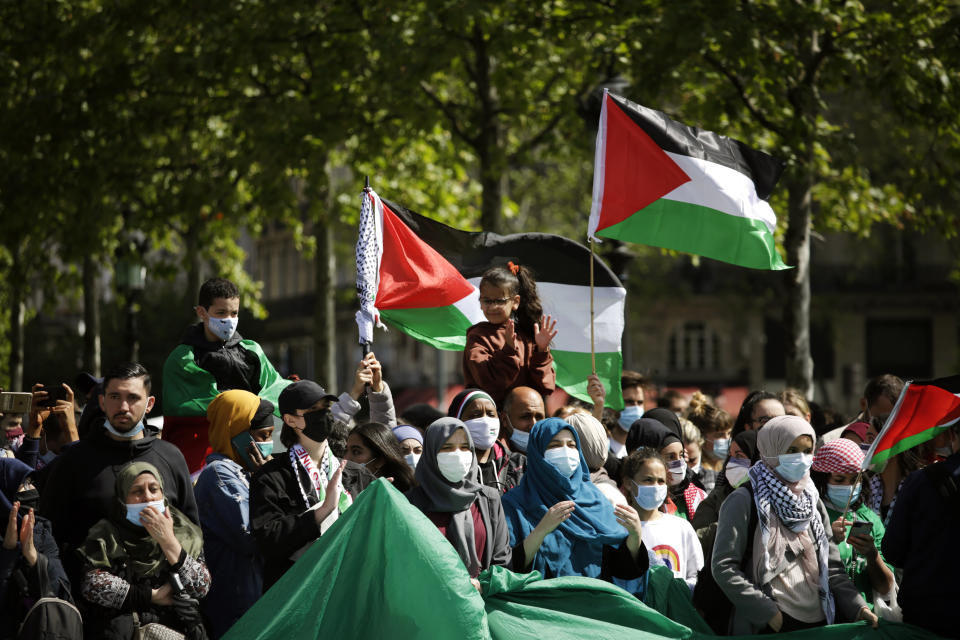 Protesters hold Palestinian flags in Paris, Saturday, May 22, 2021, as they take part in a rally supporting Palestinians. Egyptian mediators held talks Saturday to firm up an Israel-Hamas cease-fire as Palestinians in the Hamas-ruled Gaza Strip began to assess the damage from 11 days of intense Israeli bombardment.Supporters of the Palestinians. (AP Photo/Thibault Camus)