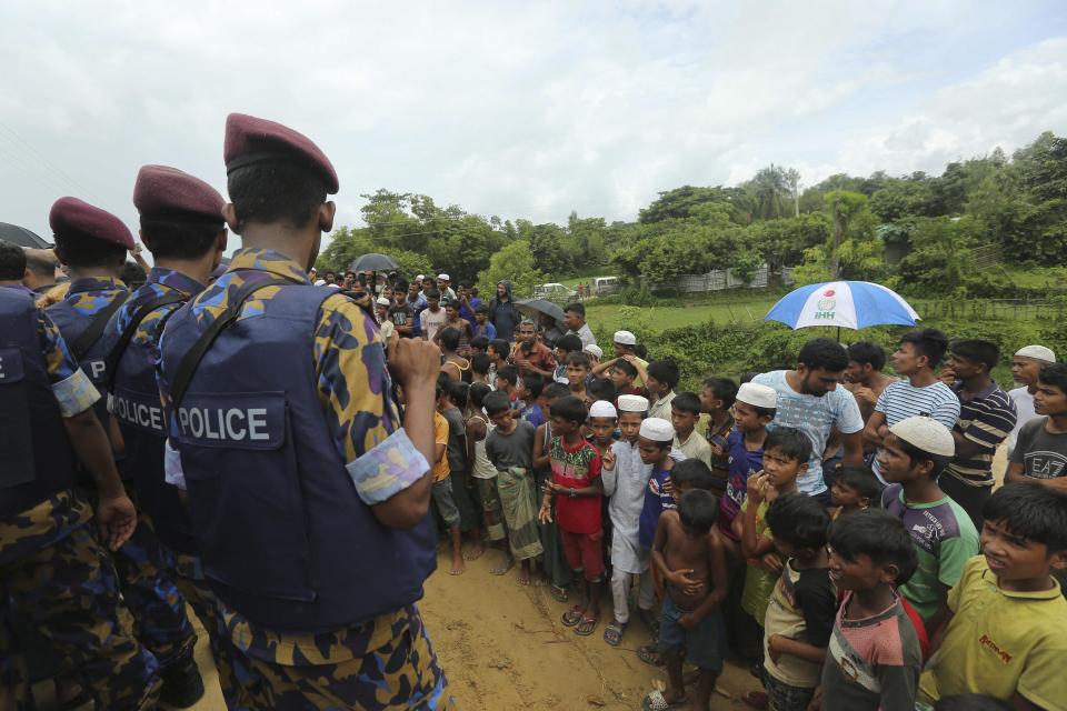 Rohingya refugee children watch Myanmarese and Chinese offcials arrive at Nayapara camp in Cox's Bazar, Bangladesh, Thursday, Aug.22, 2019. Bangladesh's refugee commissioner said Thursday that no Rohingya Muslims turned up to return to Myanmar from camps in the South Asian nation. (AP Photo/Mahmud Hossain Opu)