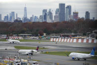 The New York City skyline is seen behind planes waiting to take off at LaGuardia Airport in New York, Wednesday, Nov. 22, 2023. (AP Photo/Seth Wenig)