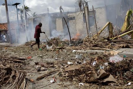 A man burns branches from fallen trees after Hurricane Matthew in Les Anglais, Haiti, October 10, 2016. REUTERS/Andres Martinez Casares