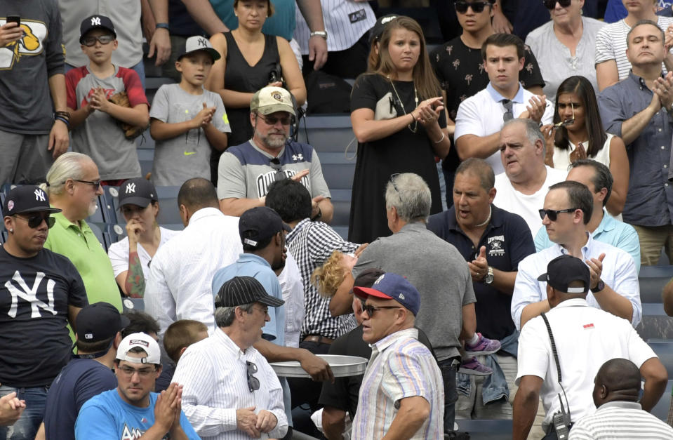 Baseball fans reacts as a young girl is carried out of the seating area after being hit by a line drive during a game at Yankee Stadium in New York. (AP)