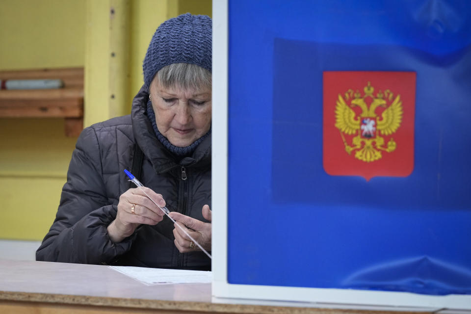 Una mujer comprueba si un bolígrafo escribe antes de rellenar su boleta para las elecciones presidenciales, en un centro de votación en San Petersburgo, Rusia, el 15 de marzo de 2024. (AP Foto/Dmitri Lovetsky)