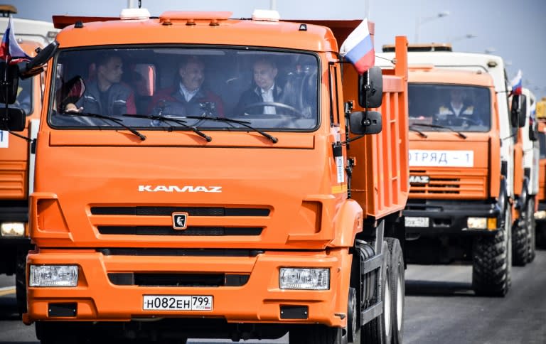 Russian President Vladimir Putin (R) drives a construction truck across the new bridge over the Kerch Strait linking mainland Russia to Moscow-annexed Crimea during the opening ceremony on May 15, 2018