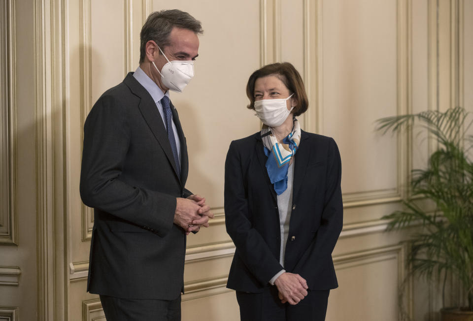 Greek Prime Minister Kyriakos Mitsotakis, left, welcomes French Defense Minister Florence Parly, during their meeting in Athens on Monday Jan. 25, 2021. Greece signed a 2.3 billion euro ($2.8 billion) deal with France Monday to purchase 18 Rafale fighter jets to address tension with neighbor Turkey. (AP Photo/Petros Giannakouris)