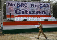 A policeman walks past a hoarding at the venue of a protest rally against a new citizenship law in Kolkata, India December 20, 2019. REUTERS/Rupak De Chowdhuri