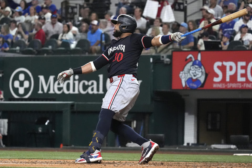 Minnesota Twins' Carlos Santana watches his home run that also scores teammates Ryan Jeffers and Manuel Margot during the fifth inning of a baseball game against the Texas Rangers in Arlington, Texas, Friday, Aug. 16, 2024. (AP Photo/LM Otero)