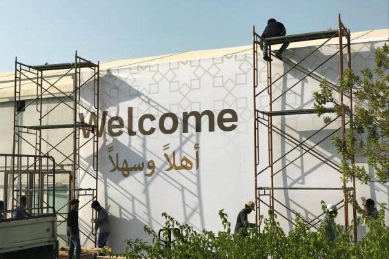 Workers place a banner at the pavilion where the US hosted event “Peace to Prosperity” takes place outside Four Seasons Hotel in Manama (Reuters)