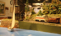 A boat sails near where trains run through the mountains. After 67 years in the Liberty Village location, The Model Railroad Club of Toronto will be moving to make way for a condo.