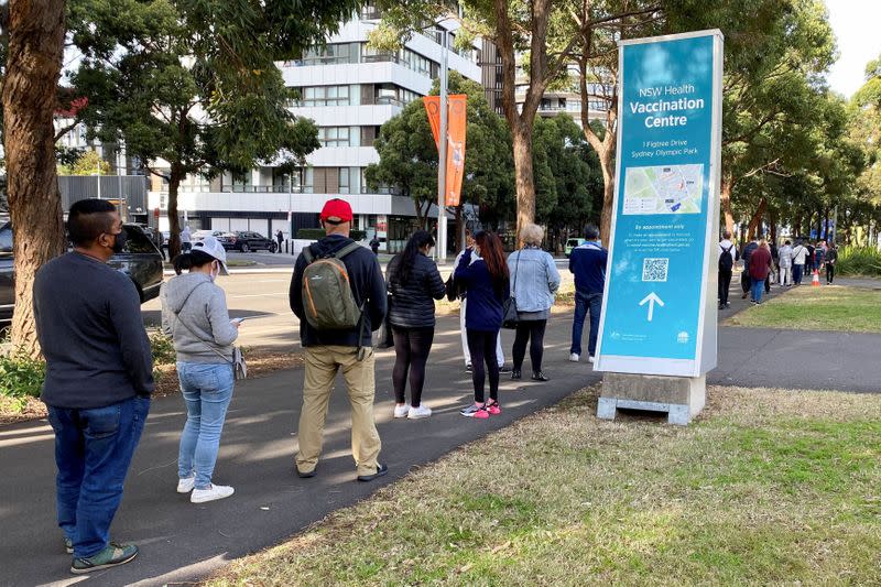 People wait in line outside a COVID-19 vaccination centre in Sydney