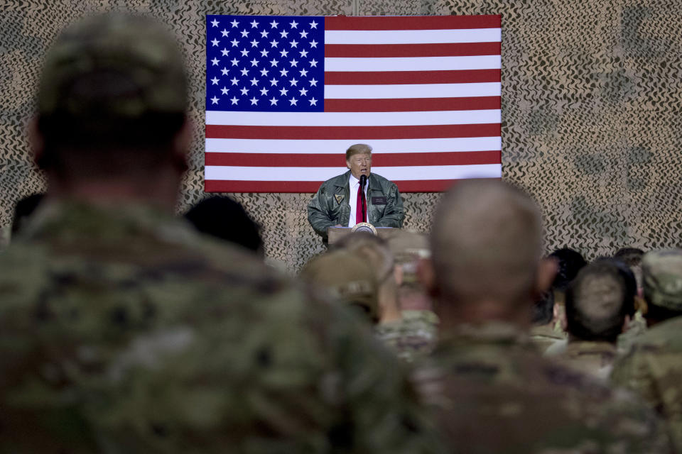 FILE - In this Dec. 26, 2018, file photo, President Donald Trump speaks to members of the military at a hangar rally at Al Asad Air Base, Iraq. President Donald Trump tells troops serving in Iraq that he got them their first pay raise in 10 years and it’s a big one. No, and not exactly. (AP Photo/Andrew Harnik, File)