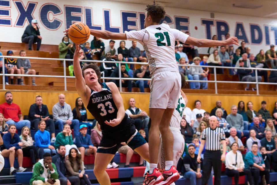 As Basha Bears point guard Elijah Summers-Livingston (21) jumps to deflect, Highland Hawks guard Noah Peterson makes a shot at the McClintock High School gym on Thursday, Dec. 29, 2022.