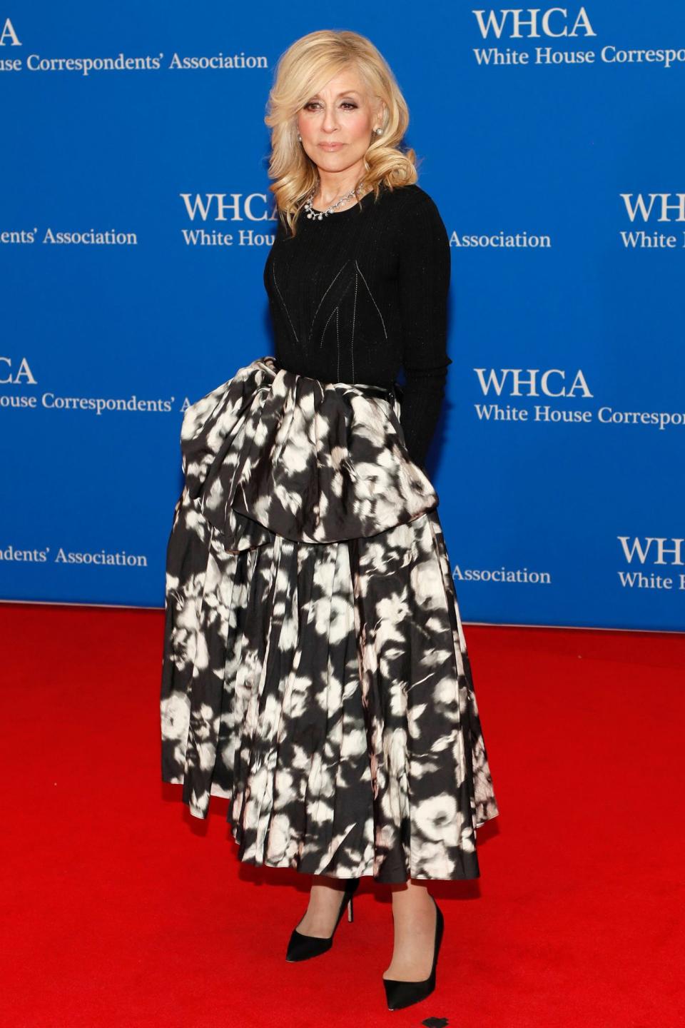 <p>wears an elegant Jason Wu design featuring a floral skirt, plus black pumps and statement jewelry. </p>