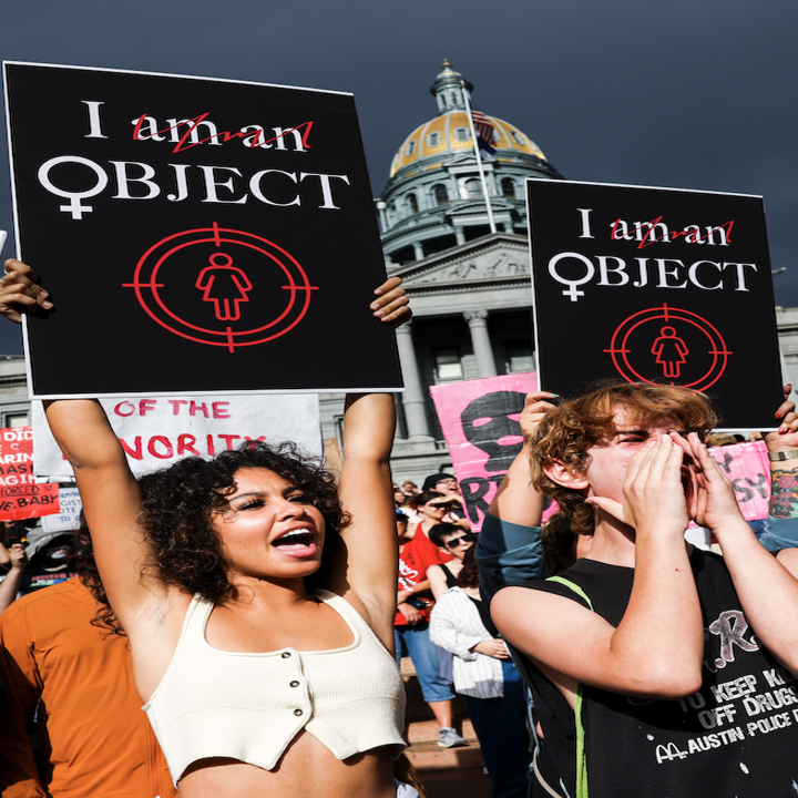 people peacefully holding up protest signs that read I object