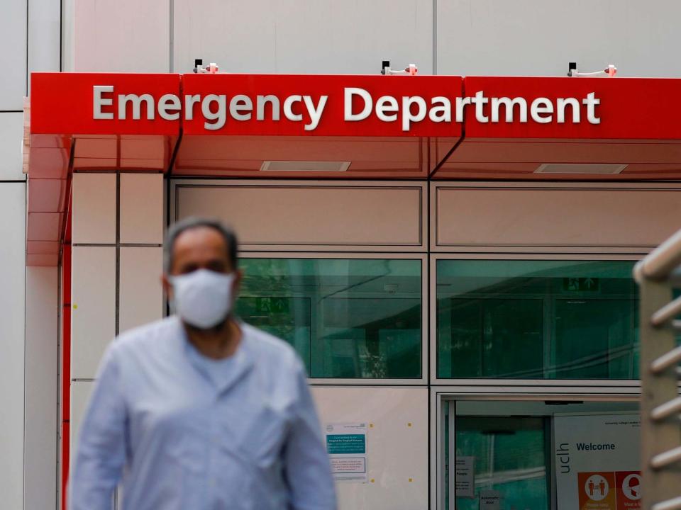 A man wearing a mask is seen walking outside the entrance to the emergency department of University College Hospital: AFP via Getty Images