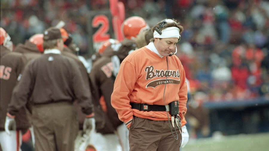 Bill Belichick, wearing brown pants and an orange sweatshirt that reads "Browns football," looks rejected.