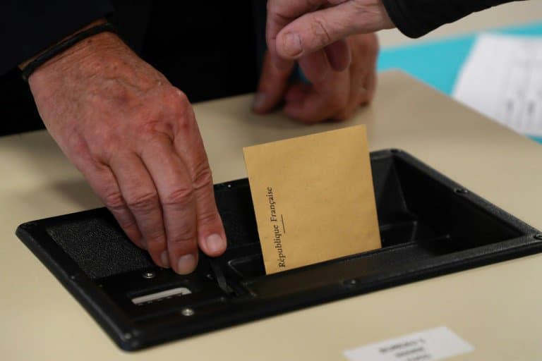 Un électeur glisse son bulletin de vote dans l'urne, le 15 mars 2020 à Cucq (Pas-de-Calais), au premier tour des élections municipales - Ludovic Marin © 2019 AFP