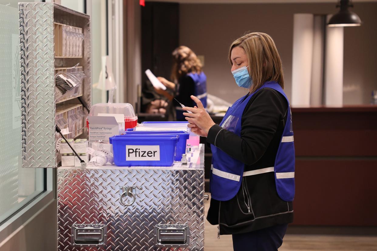 A nurse prepares doses of COVID-19 vaccines during a recent clinic.