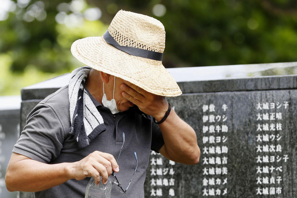 A cries as he visits "Cornerstone of Peace" monument walls on which the names of all those who lost their lives, both civilians and military of all nationalities in the Battle of Okinawa are engraved, at the Peace Memorial Park in Itoman, Okinawa, Japan, Tuesday, June 23, 2020. Okinawan people find it unacceptable that their land is still occupied by a heavy U.S. military presence even 75 years after World War II. They have asked the central government to do more to reduce their burden, and Prime Minister Shinzo Abe's government repeatedly say it is mindful of their feelings, but the changes are slow to come. (Kyodo News via AP)