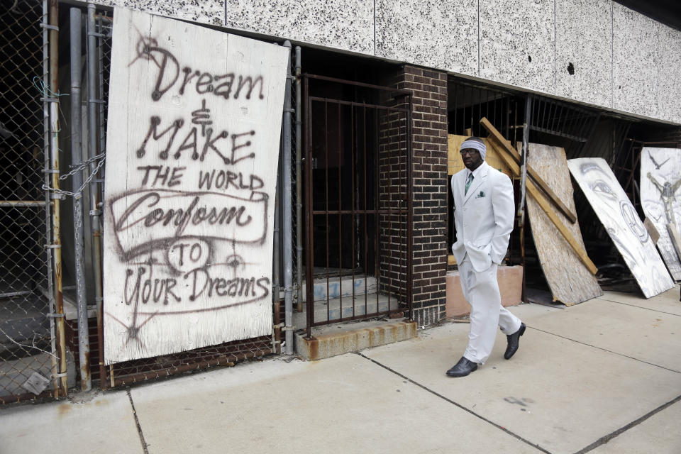 In this Thursday, Jan. 16, 2014 photo, Melvin White, founder of the Beloved Streets of America project, walks past a boarded up building during a tour of Dr. Martin Luther King Jr. Drive in St. Louis. The nonprofit is working to revitalize a downtrodden six-mile stretch of the drive named for the slain civil rights leader, marked by vacant lots, crumbling buildings and a preponderance of liquor stores, pawn shops and check-cashing businesses. Project leaders hope revitalize MLK's streets that have fallen into disrepair in cities around the country. (AP Photo/Jeff Roberson) (AP Photo/Jeff Roberson)