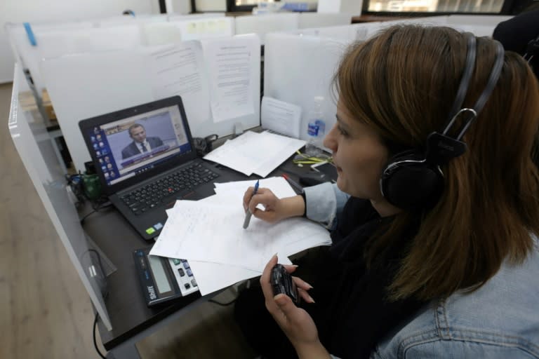 An employee of the electoral monitoring committee watches a televised speech of a Lebanese parliamentary candidate and records the time of his speech at the headquarters of the committee in Beirut on April 11, 2018