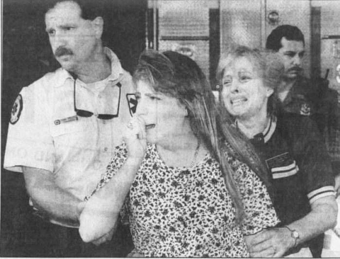 Paramedic Don Dolph leads Keri Taggart and her mother, Linda Taggart, from the Ladies Center after the July 29 shooting in 1994.