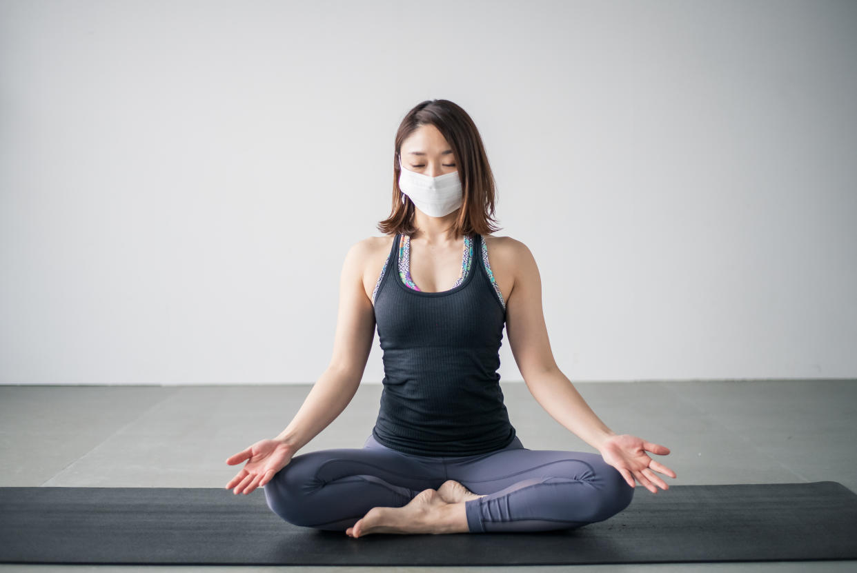 Yoga woman wearing medical face mask.