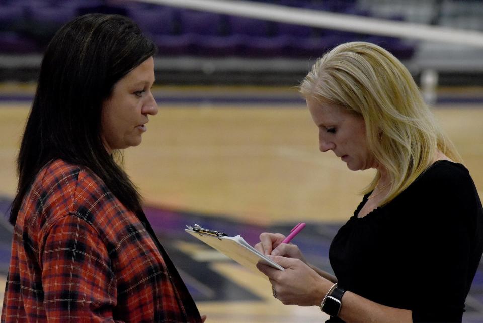 Bedford High School assistant coach Melissa (Lyczkowski) Brown (left) and head coach Bree (Hickman) Russo discuss the line-up for the third game with Monroe in the opening match of the Division 1 District at Woodhaven on Monday, October 30, 2123. The two coaches were on the 1998 Bedford state class A championship team.