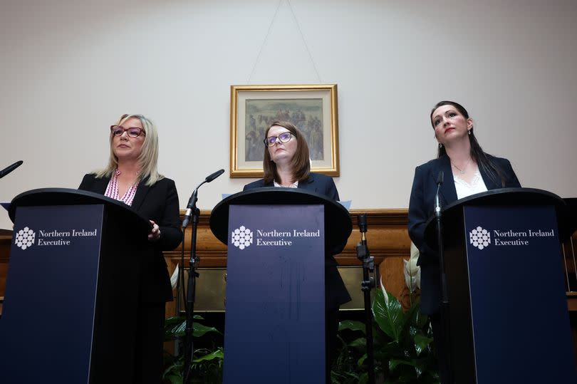 First Minister Michelle O'Neill, Finance Minister Caomihe Archibald and Deputy First Minister Emma Little-Pengelly announce the budget at Stormont Castle, all speaking at podiums