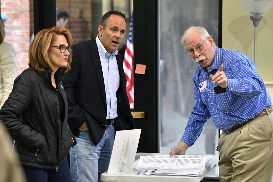 Kentucky Governor and Republican gubernatorial candidate Matt Bevin, center, and his wife Glenna Bevin are directed by a poll worker where they are to go to get their ballots for the state's general election in Louisville, Ky., Tuesday, Nov. 5, 2019. (AP Photo/Timothy D. Easley)