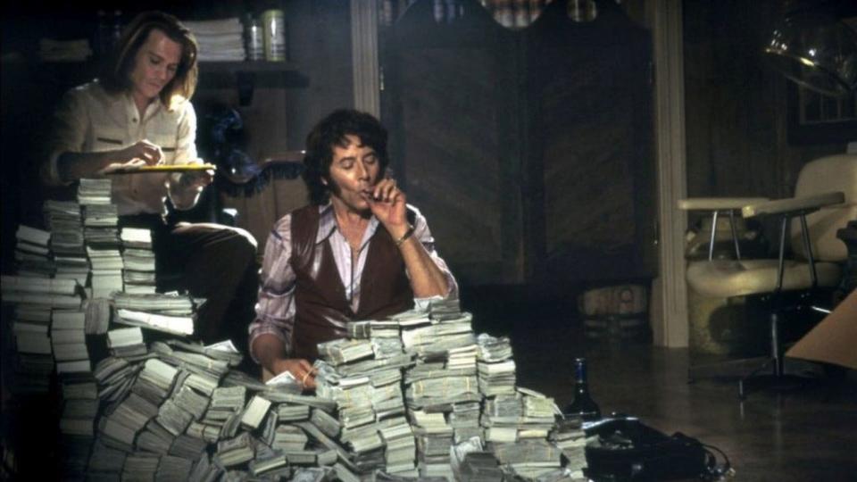 Paul Reubens and Johnny Depp surrounded by money