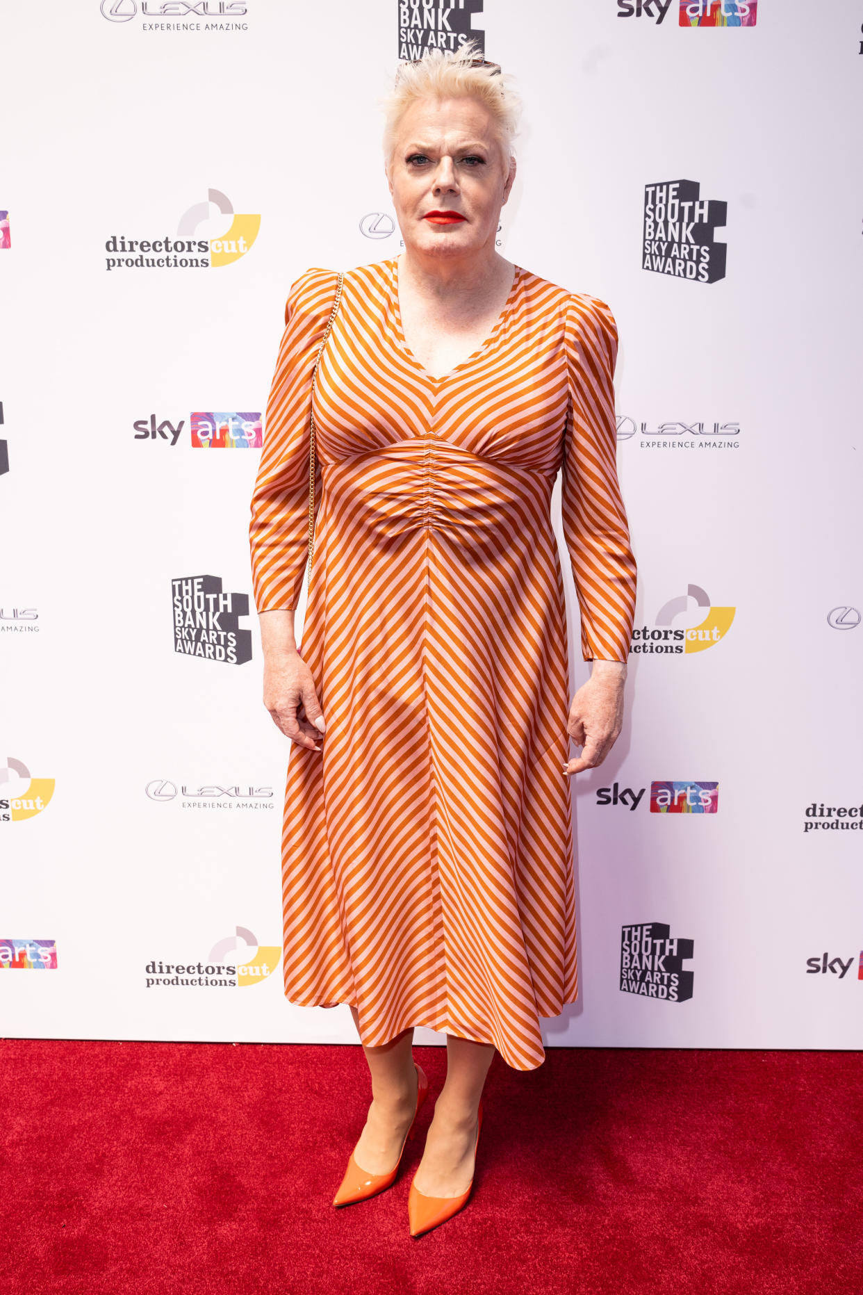 Eddie Izzard attends The South Bank Sky Arts Awards 2022 in heels and a fitted vintage-style frock.