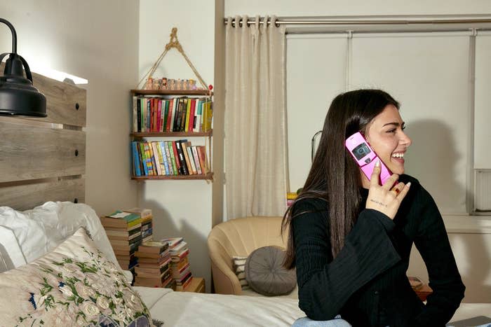 Arifi in her apartment with a Motorola Pink Razr flip phone on Jan. 12, 2023.