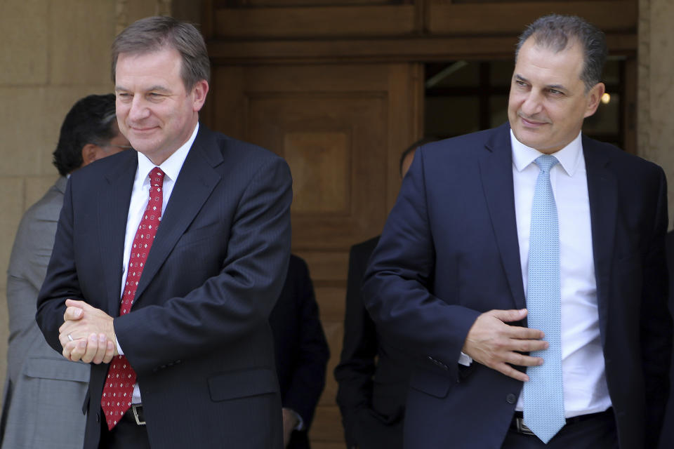 ExxonMobil Senior Vice President Neil Chapman, left and and Cyprus' Energy Minister Georgios Lakkotrypis leave after a meeting with Cyprus' president Nicos Anastasiades at the presidential palace in capital Nicosia, Cyprus, Friday Oct. 5, 2018. Chapman says the energy company will go ahead with a search for natural gas off the cost of Cyprus by the end of the year. (AP Photo/Petros Karadjias)