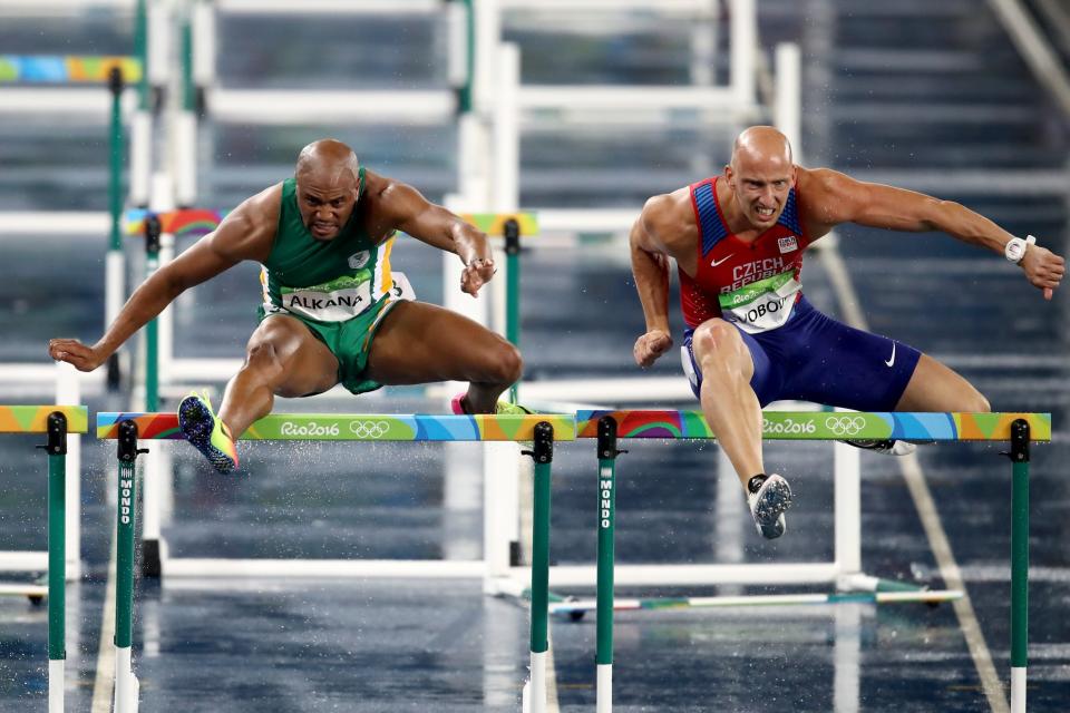 <p>Antonio Alkana of South Africa (L) and Petr Svoboda of the Czech Republic compete during the Men’s 110m Hurdles Round 1 – Heat 3. (Getty) </p>