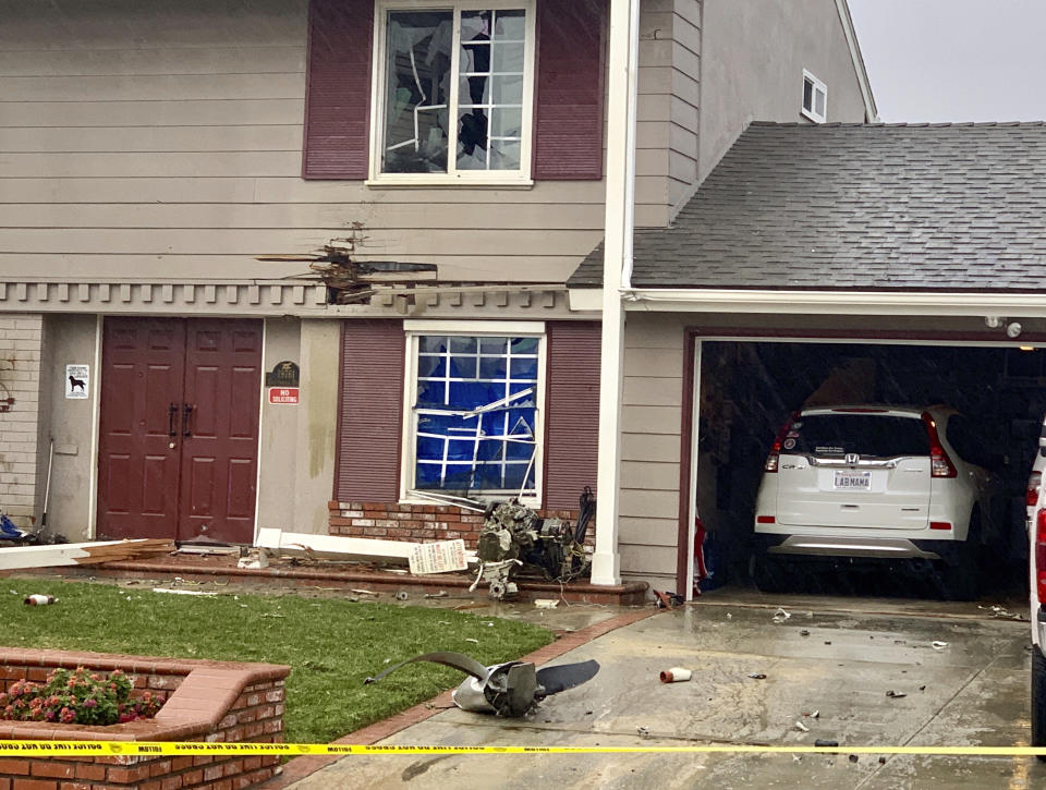 A propeller of a small plane sits on the front of a house in Yorba Linda, Calif., Sunday, Feb. 3, 2019. A twin-engine Cessna 414A crashed in Yorba Linda shortly after taking off from the nearby Fullerton Municipal Airport. (AP Photo/Alex Gallardo)